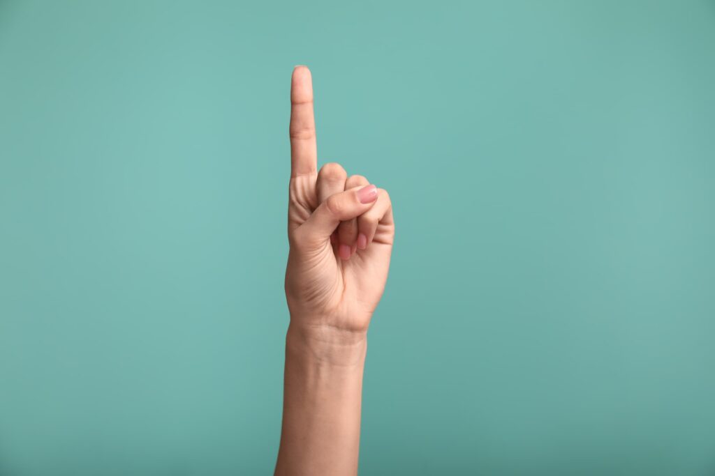 A hand in a fist with its index finger pointing up indicating “one”