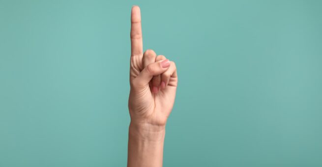 A hand in a fist with its index finger pointing up indicating “one”